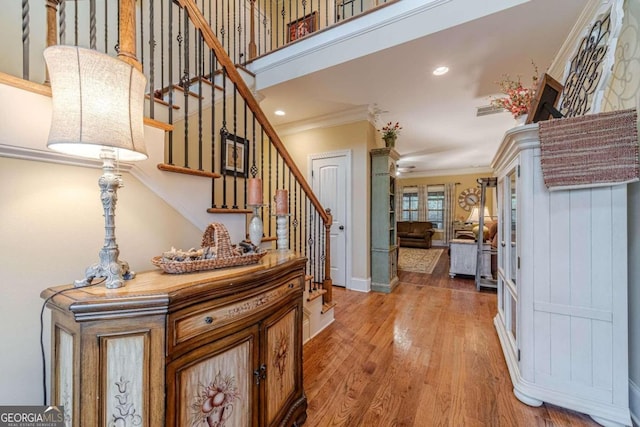 foyer with wood-type flooring and ornamental molding