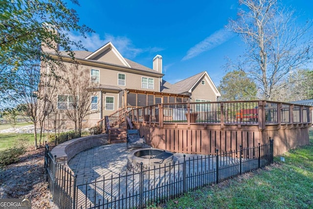 back of house featuring a patio, a fire pit, and a deck