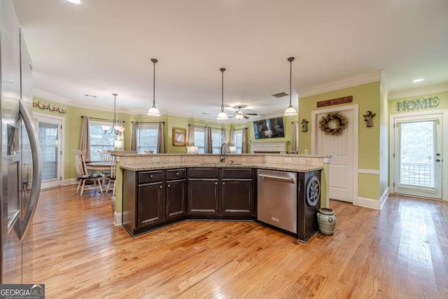 kitchen featuring a wealth of natural light, a center island with sink, and stainless steel appliances