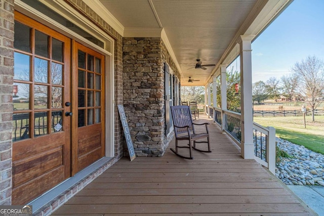 wooden deck featuring ceiling fan, covered porch, and french doors