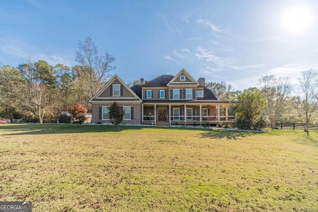 view of front of house with covered porch and a front lawn