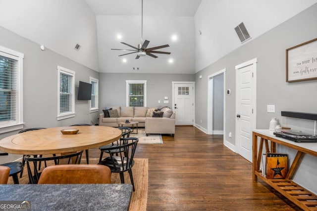 dining space with dark hardwood / wood-style flooring, high vaulted ceiling, and ceiling fan