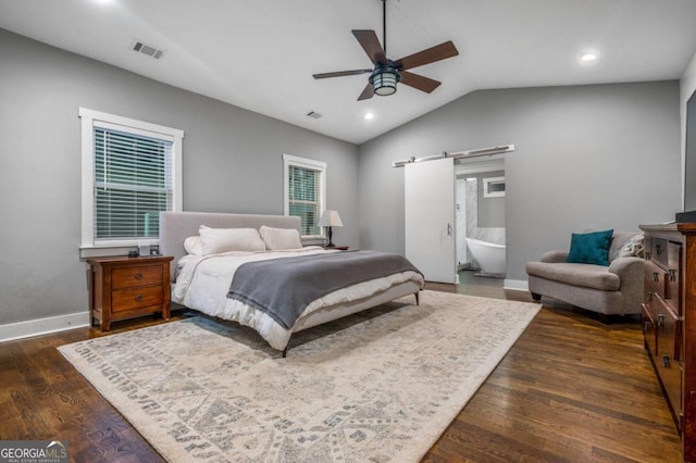 bedroom featuring ceiling fan, ensuite bathroom, lofted ceiling, and dark wood-type flooring