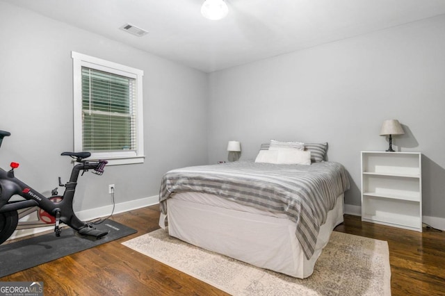 bedroom with dark hardwood / wood-style floors