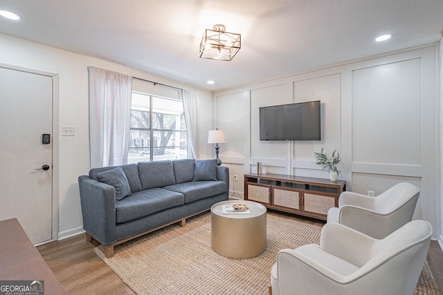 living room with light hardwood / wood-style flooring and a textured ceiling