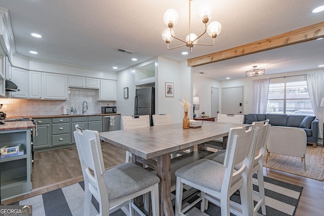 115 Lucian Cir, Savannah, GA 31406 - dining area with a chandelier, wood finished floors, a textured ceiling, and recessed lighting