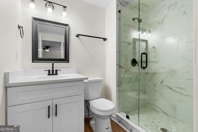 bathroom featuring walk in shower, vanity, ceiling fan, hardwood / wood-style flooring, and toilet