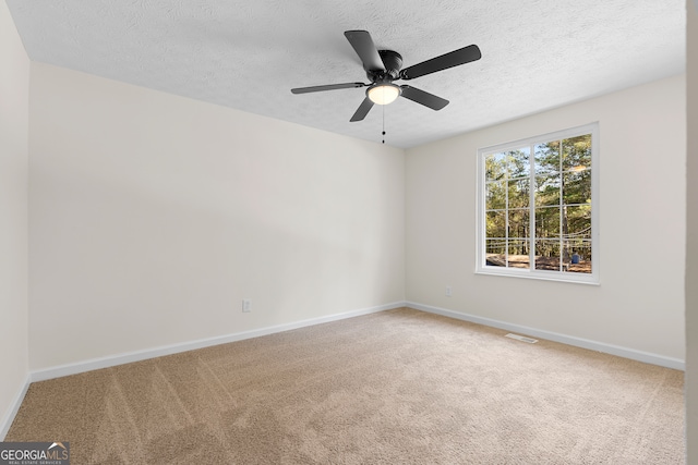 spare room featuring carpet, a textured ceiling, and ceiling fan