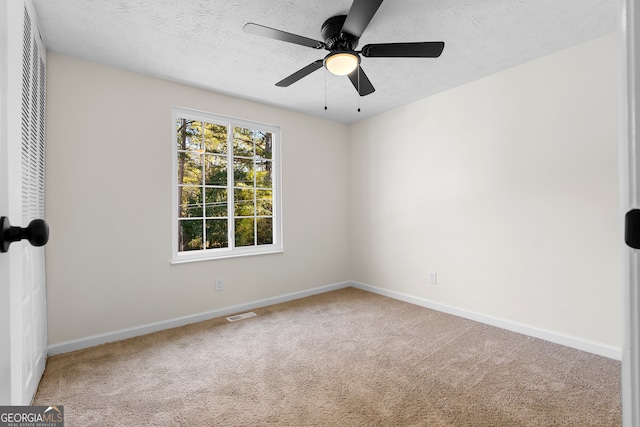 carpeted spare room with ceiling fan and a textured ceiling