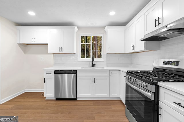 kitchen with white cabinetry, sink, stainless steel appliances, and light wood-type flooring