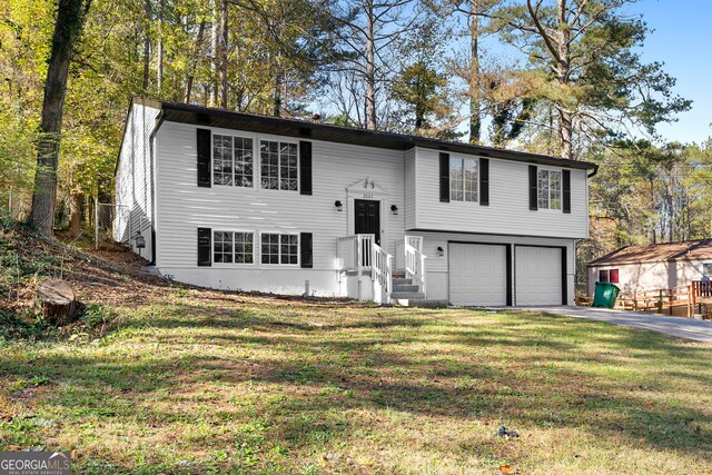 raised ranch with a garage and a front yard