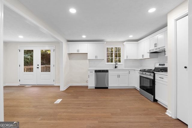 kitchen featuring french doors, light wood-type flooring, stainless steel appliances, and white cabinetry