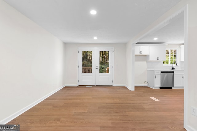 foyer with plenty of natural light, light hardwood / wood-style floors, and french doors