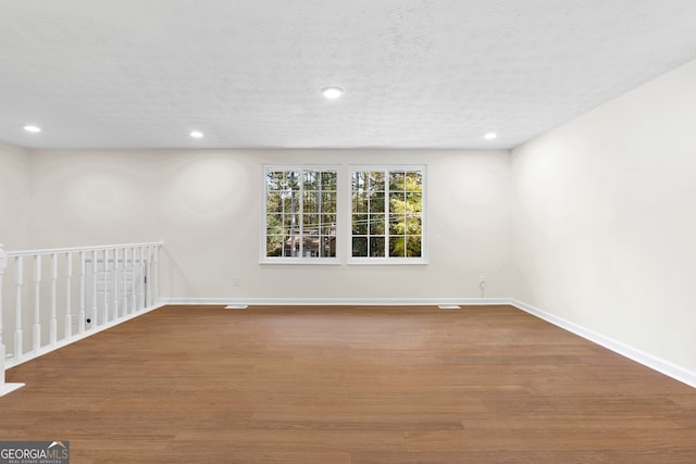 unfurnished room featuring hardwood / wood-style floors and a textured ceiling