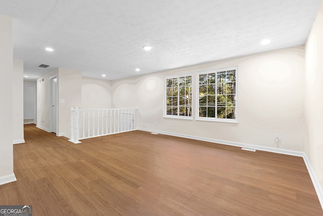 spare room with wood-type flooring and a textured ceiling