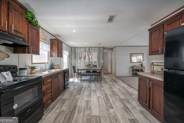 kitchen with sink, dark brown cabinets, black appliances, light hardwood / wood-style floors, and a textured ceiling