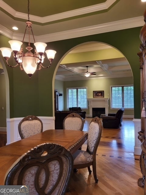 dining area featuring hardwood / wood-style floors, crown molding, plenty of natural light, and coffered ceiling