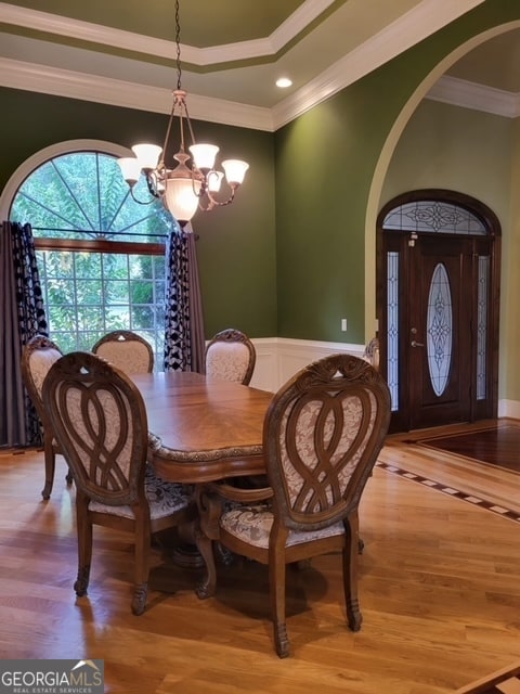 dining room featuring crown molding, a chandelier, and light wood-type flooring