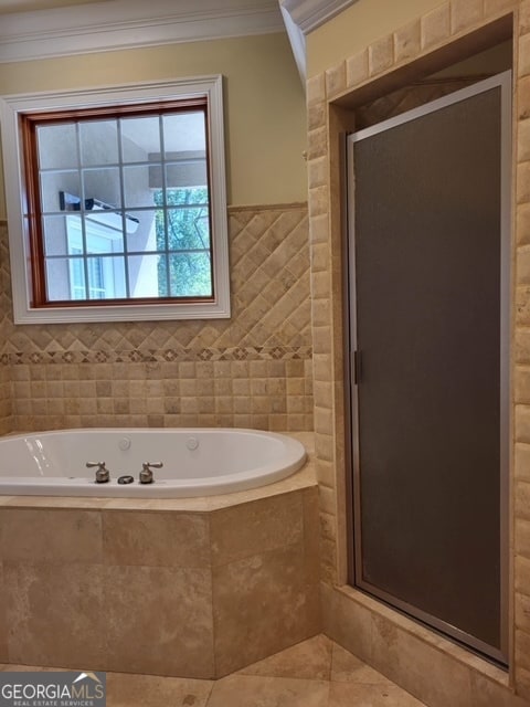 bathroom with separate shower and tub, tile walls, and ornamental molding