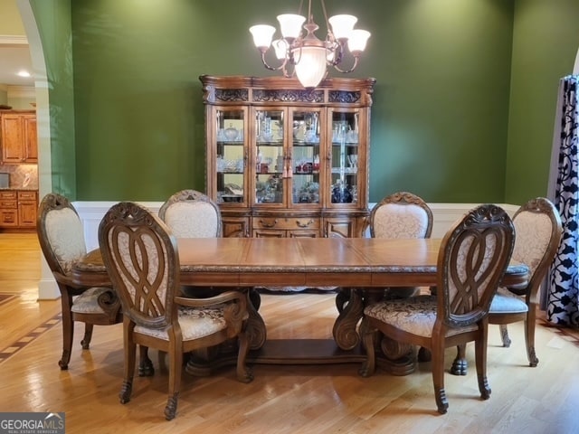 dining area featuring light wood-type flooring and a notable chandelier