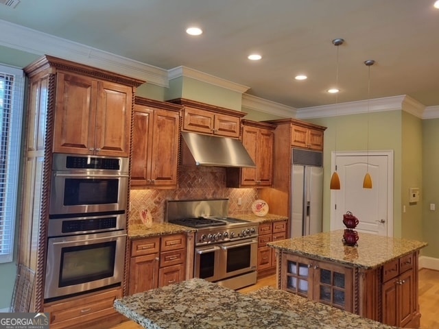 kitchen featuring light stone countertops, a center island, and stainless steel appliances