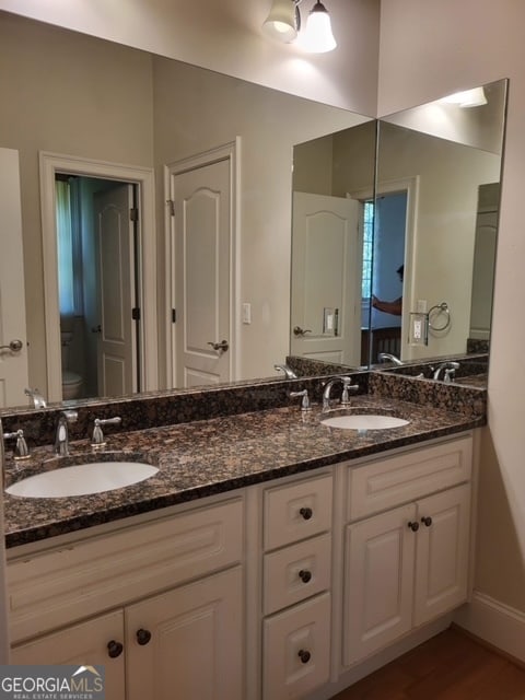 bathroom featuring hardwood / wood-style flooring, vanity, and toilet