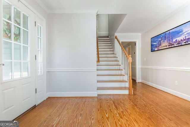 entryway with crown molding and light hardwood / wood-style flooring