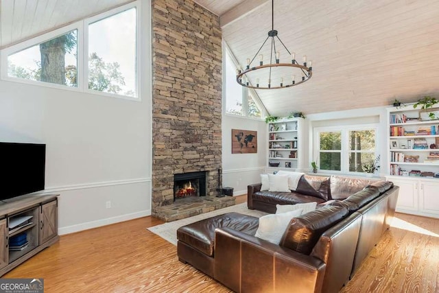 living room featuring a fireplace, light wood-type flooring, a wealth of natural light, and wooden ceiling