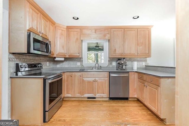 kitchen with light brown cabinets, stainless steel appliances, light hardwood / wood-style floors, and sink