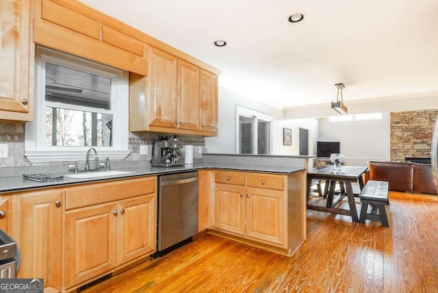 kitchen featuring decorative backsplash, sink, stainless steel dishwasher, and light hardwood / wood-style floors