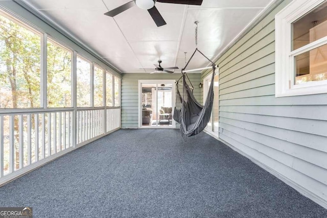 unfurnished sunroom with ceiling fan