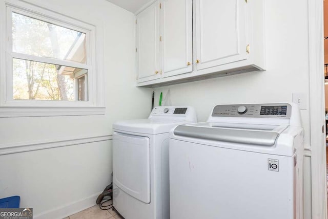 laundry room featuring light tile patterned flooring, cabinets, and separate washer and dryer