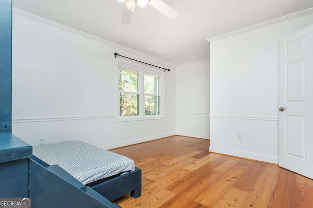 bedroom with hardwood / wood-style flooring, ceiling fan, and ornamental molding