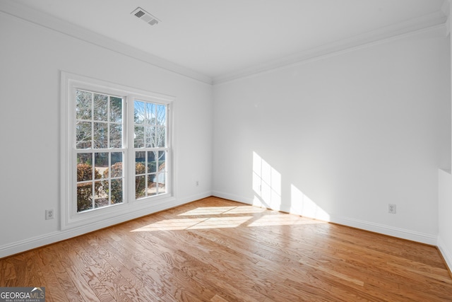 spare room featuring crown molding and light hardwood / wood-style floors