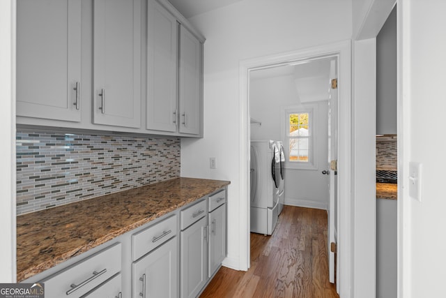 laundry room featuring washing machine and clothes dryer and light hardwood / wood-style floors