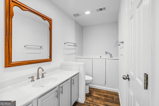 bathroom with wood-type flooring, toilet, and vanity