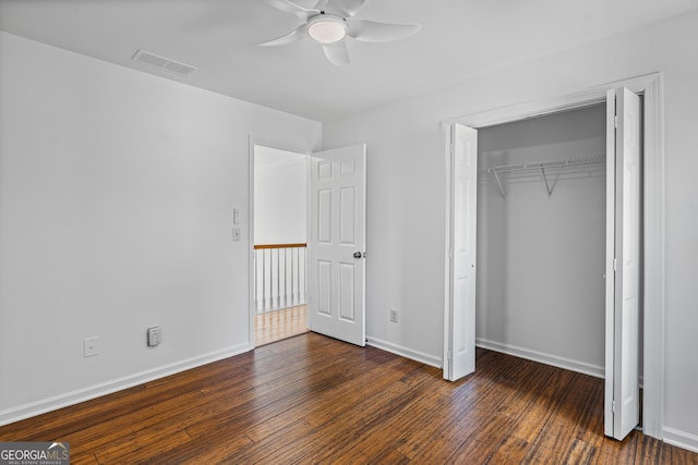 unfurnished bedroom with dark wood-type flooring, ceiling fan, and a closet