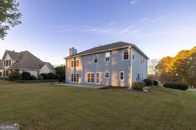 back of house featuring a patio and a lawn