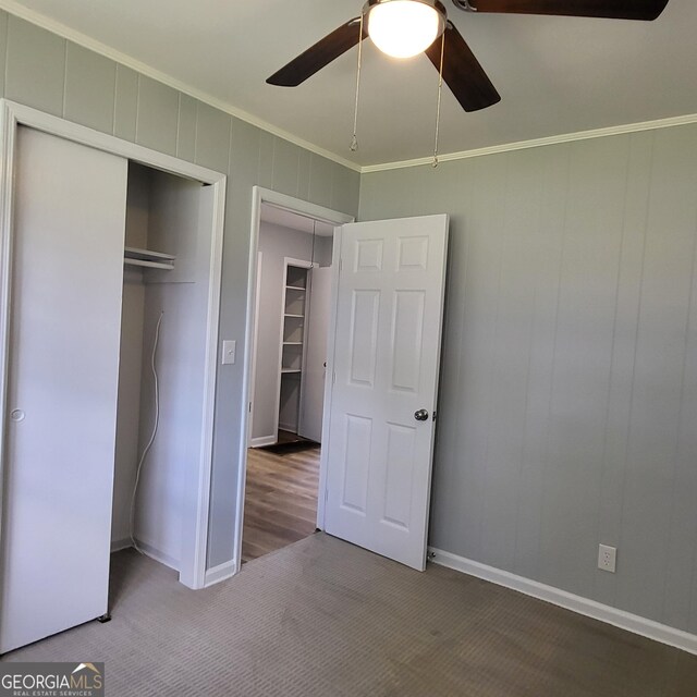 unfurnished room with ceiling fan and dark carpet