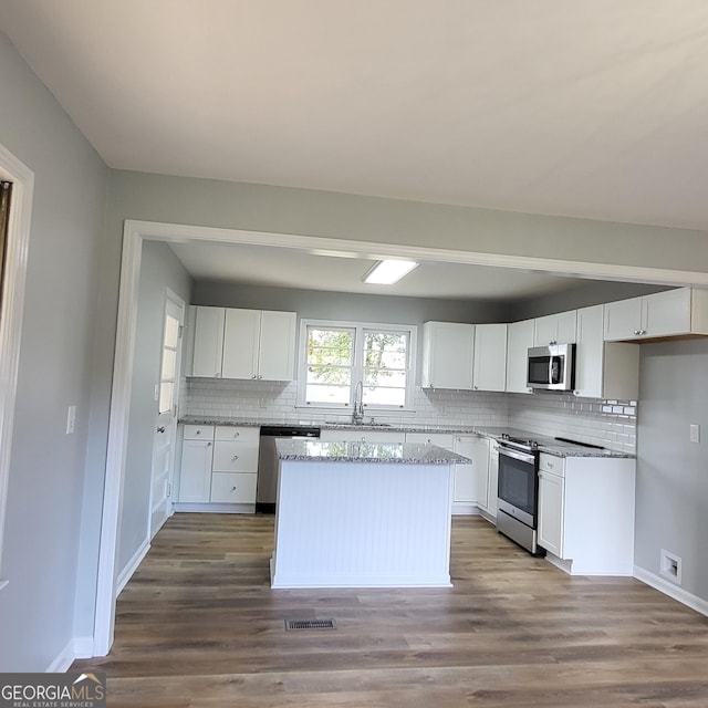 spare room with dark wood-type flooring and ceiling fan with notable chandelier