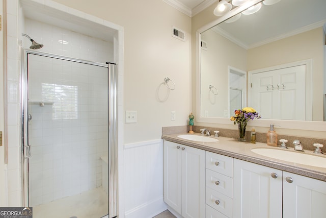 bathroom featuring vanity, a shower with shower door, and ornamental molding