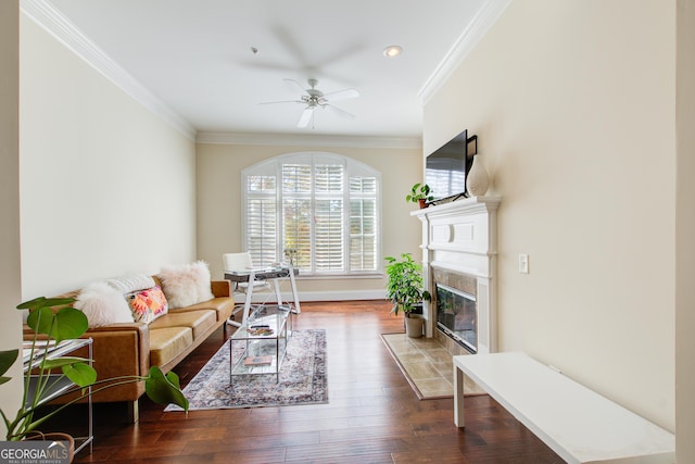 living room with a fireplace, hardwood / wood-style flooring, ceiling fan, and crown molding