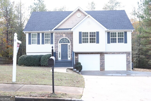 bi-level home featuring a garage and a front lawn