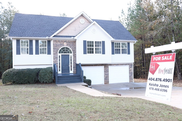 bi-level home with a garage and a front lawn