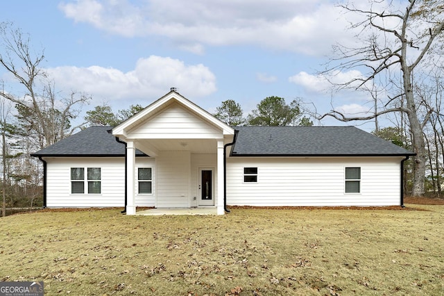 back of house with a yard and a patio