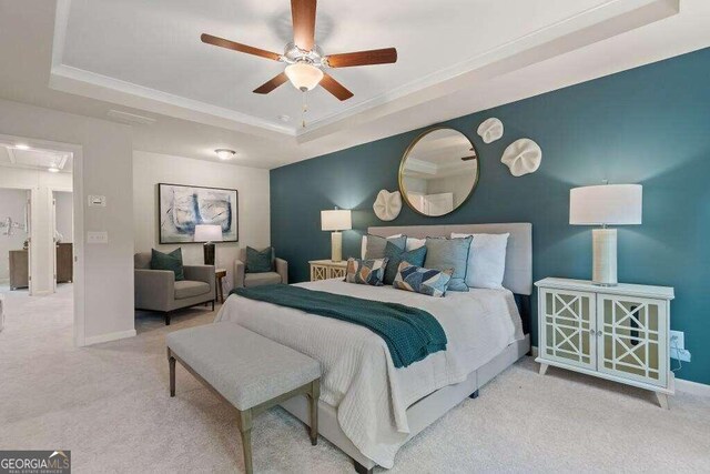 bedroom featuring ceiling fan, light colored carpet, crown molding, and a tray ceiling