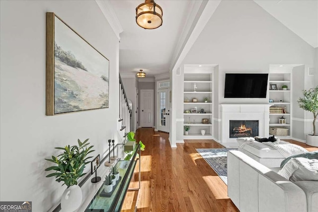 living room with ornamental molding, hardwood / wood-style flooring, and lofted ceiling