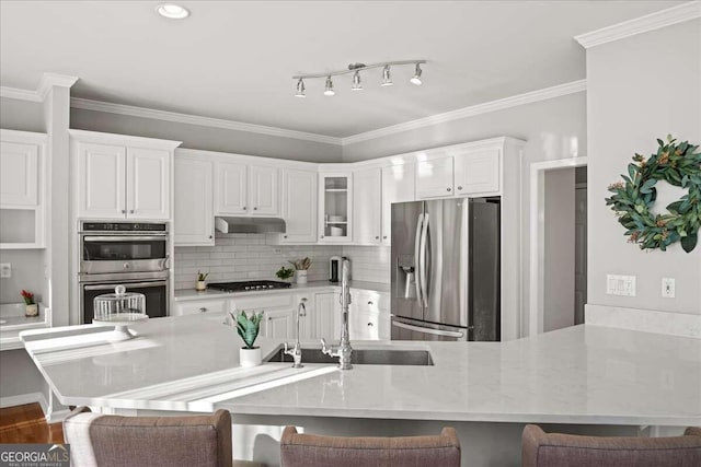 kitchen with a kitchen breakfast bar, white cabinetry, ornamental molding, and appliances with stainless steel finishes