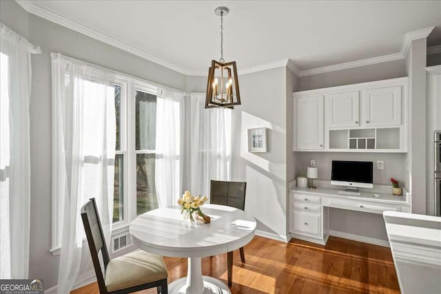 dining room with crown molding, built in desk, and dark wood-type flooring