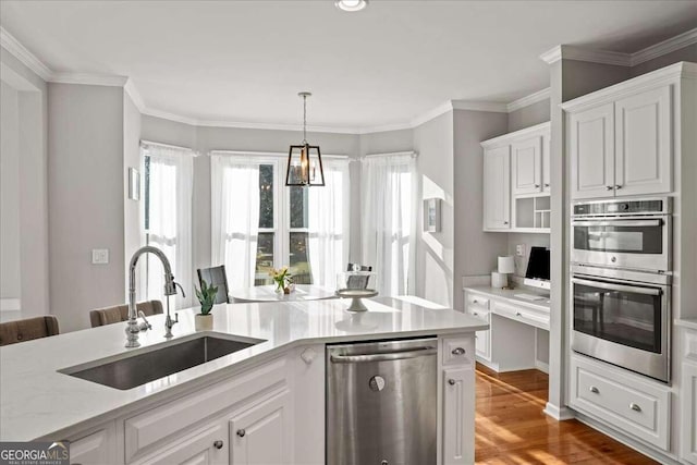 kitchen featuring white cabinets, crown molding, sink, light wood-type flooring, and appliances with stainless steel finishes